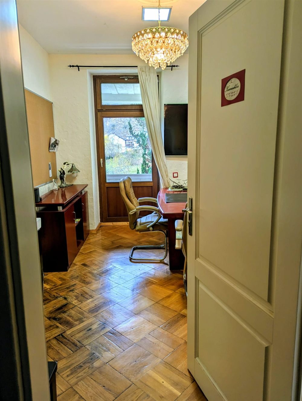 Blick durch die offene Tür in den Meetingraum Kaiserschloss mit Parkett, Kronleuchter und Besprechungstisch